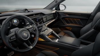Interior de un Porsche Cayenne eléctrico con un enfoque en el puesto del conductor, el tablero digital y la iluminación ambiental en los paneles de las puertas.