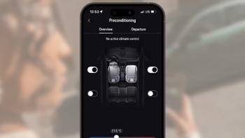 Primer plano de un smartphone que muestra la aplicación de Porsche, con opciones de preacondicionamiento y programación de la carga del vehículo.
