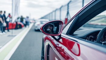 Chofer se ve por el espejo de un auto Porsche