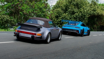 Porsche 911, color gris y de color celeste, andando en carretera