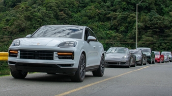 Fila de Porsche en carretera teniendo en primer plano a Porsche Cayenne color gris en Road Tour Lago Calima