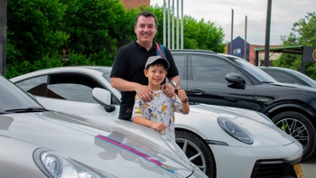 Padre e hijo entre varios modelos de Porsche en Porsche Road Tour Lago Calima