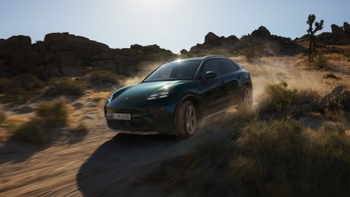 Green sporty compact SUV Porsche Macan on an offroad drive in a sand-covered area