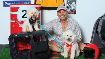 Hombre celebrando con su mascota el Día del Perro en el concesionario Porsche de Cancún