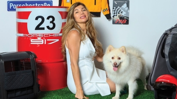 Mujer celebrando con su mascota el Día del Perro en el concesionario Porsche de Cancún