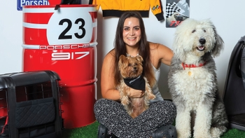 Joven celebrando con su mascota el Día del Perro en el concesionario Porsche de Cancún