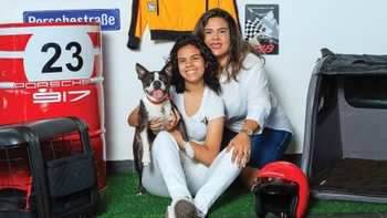 Pareja celebrando con su mascota el Día del Perro en el concesionario Porsche de Cancún