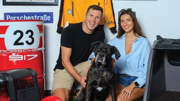 Pareja celebrando con su mascota el Día del Perro en el concesionario Porsche de Cancún