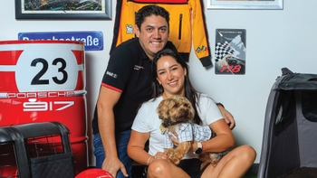 Pareja celebrando con su mascota el Día del Perro en el concesionario Porsche de Cancún