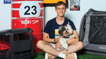 Joven celebrando con su mascota el Día del Perro en un concesionario Porsche de Cancún