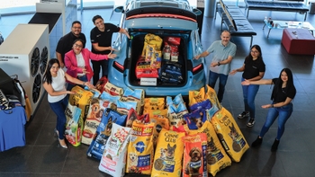 Grupo de personas con bolsas de comida para perro en auto Porsche