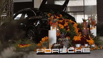 Porsche negro adornado con flores de cempasúchil y elementos del Día de Muertos, celebrando la tradición mexicana.