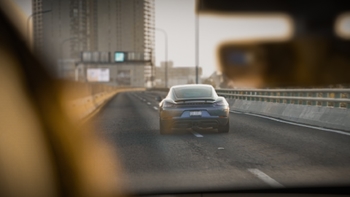 Porsche 718 Cayman color azul corriendo por la carretera