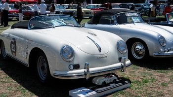 Porsche 356 Speedster blanco con un modelo a escala y otro 356 convertible en exhibición durante un evento al aire libre.