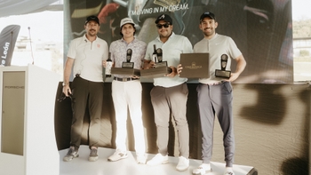 Cuatro golfistas sosteniendo trofeos, un vino y un reconocimiento de Casa Madero en evento de la Porsche Golf Cup.