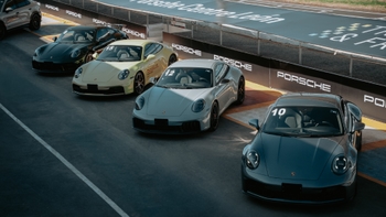 Varios Porsche 911 de diferentes colores alineados en una pista de carreras, con la marca "Porsche Centre León" visible.
