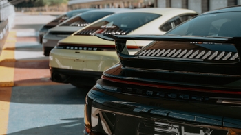 Vista trasera de varios Porsche 911 alineados, destacando sus alerones y diferentes colores.