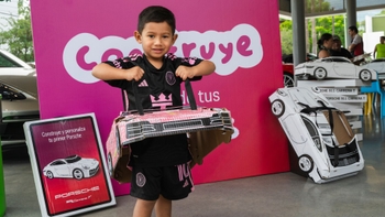 Niño con Porsche de papel en Porsche Centre