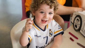 Niño sonriendo con color en la mano