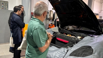 Porsche clients looking at a car engine
