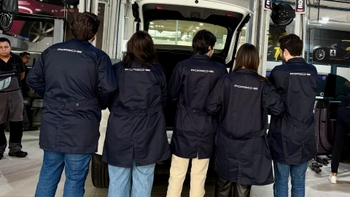 Five Porsche technicians lined up one next to the other