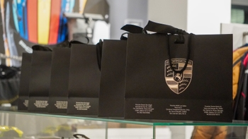 Bolsas negras de marca Porsche, con detalles de concesionarios como Porsche Centre San Angel y Porsche NOW Los Cabos.