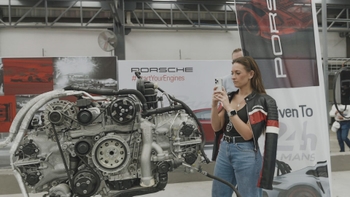 Woman taking picture of cars and engines exhibit at Le Mans Watching Party