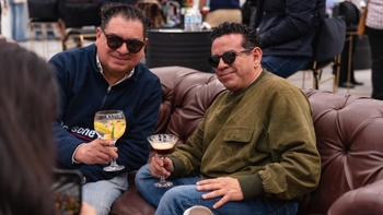 Two men enjoying some drinks at a leather coach at Le Mans Watching Party