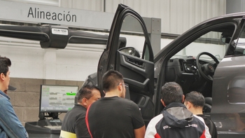 Técnico Porsche en taller de servicio con clientes