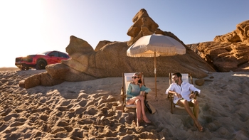 Hombre y mujer en sus sillas de playa observando el mar