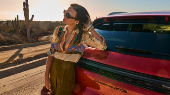 Mujer recostada en auto Porsche