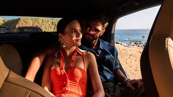 Pareja abrazada dentro de un auto Porsche