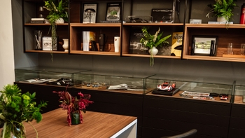 Mesa con sándwiches, pasteles y bebidas con el logo de Porsche, en un ambiente moderno.