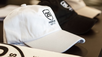 Primer plano de gorras Porsche México en blanco y negro con el logo del 25 aniversario.