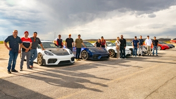 personas y fila de porsche en pista al aire libre