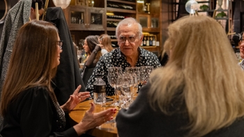 Hombre mayor tomando un sorbo de vino tinto en copa durante la cena privada en NOMA.