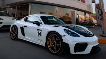 porsche 718 cayman gt4 rs estacionado frente a concesionaria