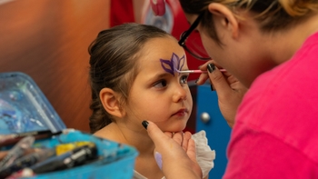 Niña recibiendo pintura facial.