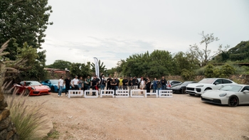 Porsche model range and guests posing with Porsche sign