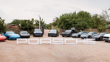 Porsche range models posing in front of the Porsche sign