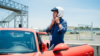 Piloto acomodandose el casco antes de subirse al auto Porsche