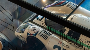 this is a white classic Porsche on display in glass