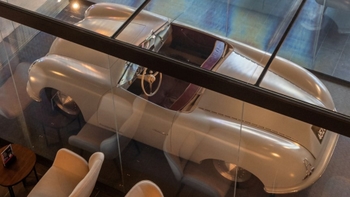 this is a silver classic Porsche on display in glass