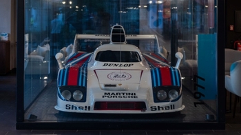 this is a white classic Porsche on display in glass