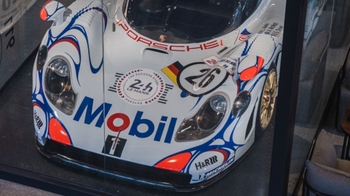 this is a white classic Porsche on display in glass