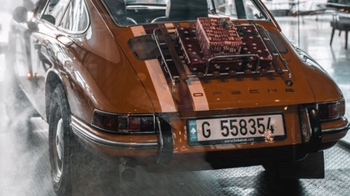 this is an orange classic Porsche on display in glass