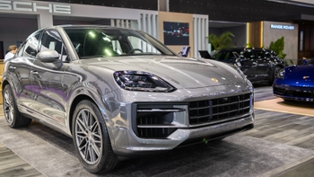 Porsche Cayenne Coupé gris exhibido en un evento o salón de automóviles, destacando su diseño frontal y rines.