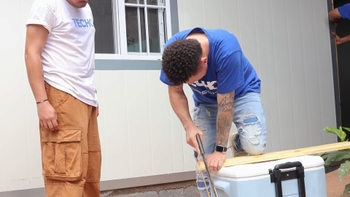 Hombre serruchando una tabla