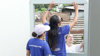 Jóvenes construyendo la ventana de una casa