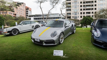 porsche 911 turbo s color gris con franja amarilla en exhibicion al aire libre en aniversario porsche peru